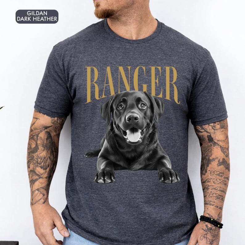 May include: Dark grey t-shirt with a black Labrador Retriever illustration and the word "RANGER" in gold. The shirt is a Gildan brand.