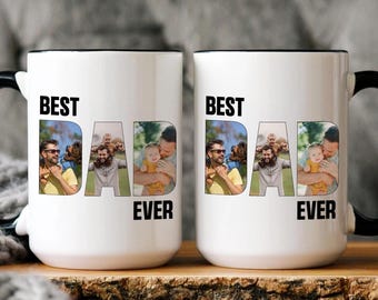 May include: Two white ceramic mugs with black rims and handles. Each mug features a photo collage of a father and child with the text "Best Dad Ever" printed on the front.