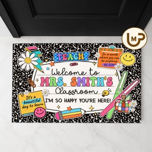 May include: A classroom doormat with a black and white composition notebook paper design. The mat features colorful illustrations and text that reads "Welcome to Mrs. Smith's Classroom" and "I'm so happy you're here!"