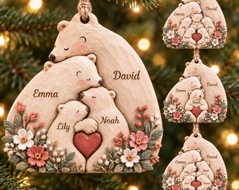 May include: A beige, flat, wooden ornament shaped like a group of bears huddled together. The bears are engraved with the names David, Emma, Lily, and Noah. A red heart is held by the bears, and the base is decorated with pink and white flowers.