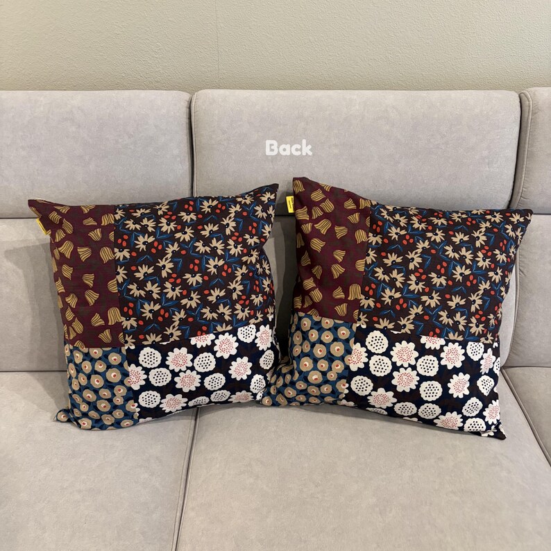 May include: Two square throw pillows featuring a patchwork design with four distinct fabric sections. The patterns include dark maroon with yellow shapes, a dense floral print, a blue and tan circular motif, and a black and white floral print.