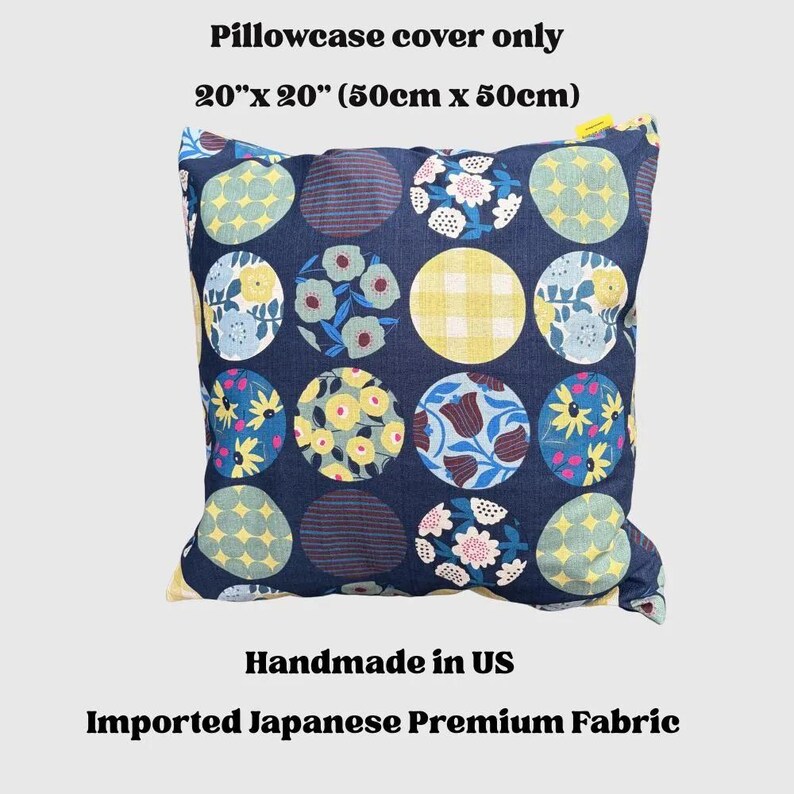 May include: A square pillowcase cover measuring 20 inches by 20 inches. The fabric is dark blue and features a repeating pattern of circles, each containing different floral, gingham, or striped designs in yellow, white, light blue, and pink.