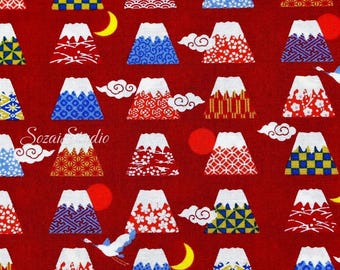 May include: A red fabric featuring a repeating pattern of stylized Mount Fuji illustrations. Each mountain has a white snow cap and is decorated with various patterns in blue, red, yellow, and white. The design includes clouds, moons, and a crane.