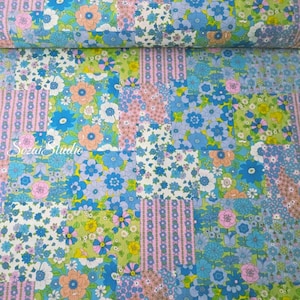 May include: A patchwork fabric with a floral pattern in shades of blue, pink, green, and white. The fabric features a variety of flower designs, including daisies and other stylized blooms. The text "Sozai Studio" is visible in the lower left corner.