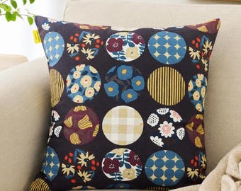 Peut inclure: Un coussin carré avec un fond gris anthracite foncé orné d'un motif répétitif de cercles. Chaque cercle présente des designs distincts, notamment des fleurs bleues et jaunes, des rayures jaunes, un motif vichy beige et des pois bleus.
