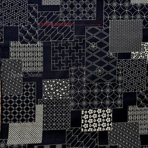 May include: A dark navy blue fabric featuring a patchwork design of various white geometric and floral patterns. The textile includes a red arrow with the text Cutting direction and the word SenseiStudio printed in white script on the left side.