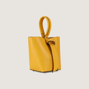 May include: A small, yellow leather bucket bag with a top handle and a knotted strap.