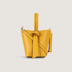 May include: A small yellow leather bucket bag with a knotted strap and a top handle.