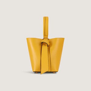 May include: A small yellow leather bucket bag with a knotted handle.