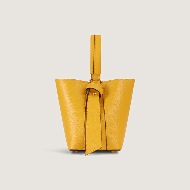 May include: A small yellow leather bucket bag with a knotted handle.