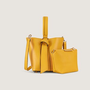 May include: A yellow leather bucket bag with a knotted strap and a matching smaller pouch.