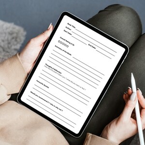 Peut inclure: Une tablette numérique affichant un modèle de critique de livre. La tablette est tenue par une personne portant un pull beige et assise sur une chaise. Un stylet blanc est tenu dans l'autre main de la personne. Le modèle comprend des champs pour le titre du livre, l'auteur et l'évaluation.