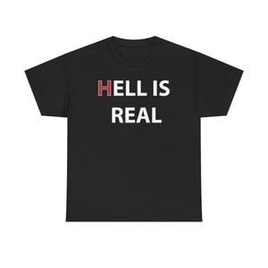 May include: Black t-shirt with the white text "HELL IS REAL". The word "HELL" is in red. The shirt is made of a soft material and has a crew neck.