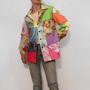 May include: A colourful patchwork shirt with a button-up front and long sleeves. The shirt is made of different fabrics and patterns, including floral, paisley, and geometric designs. The shirt is a vibrant mix of pink, green, blue, yellow, and orange.