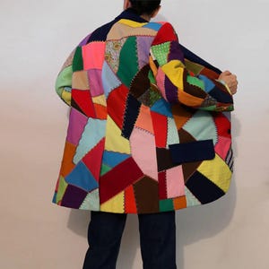 Op de afbeelding: Een kleurrijk patchwork blazer met verschillende kleuren en patronen, waaronder rood, blauw, groen, geel en roze.