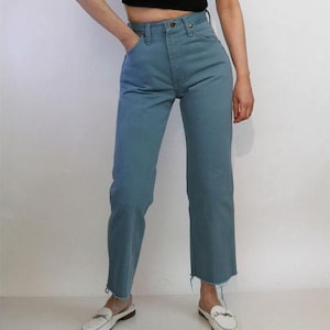 May include: A pair of light blue denim jeans with a high waist and a straight leg fit. The jeans have a frayed hem and are made of a soft, comfortable fabric.