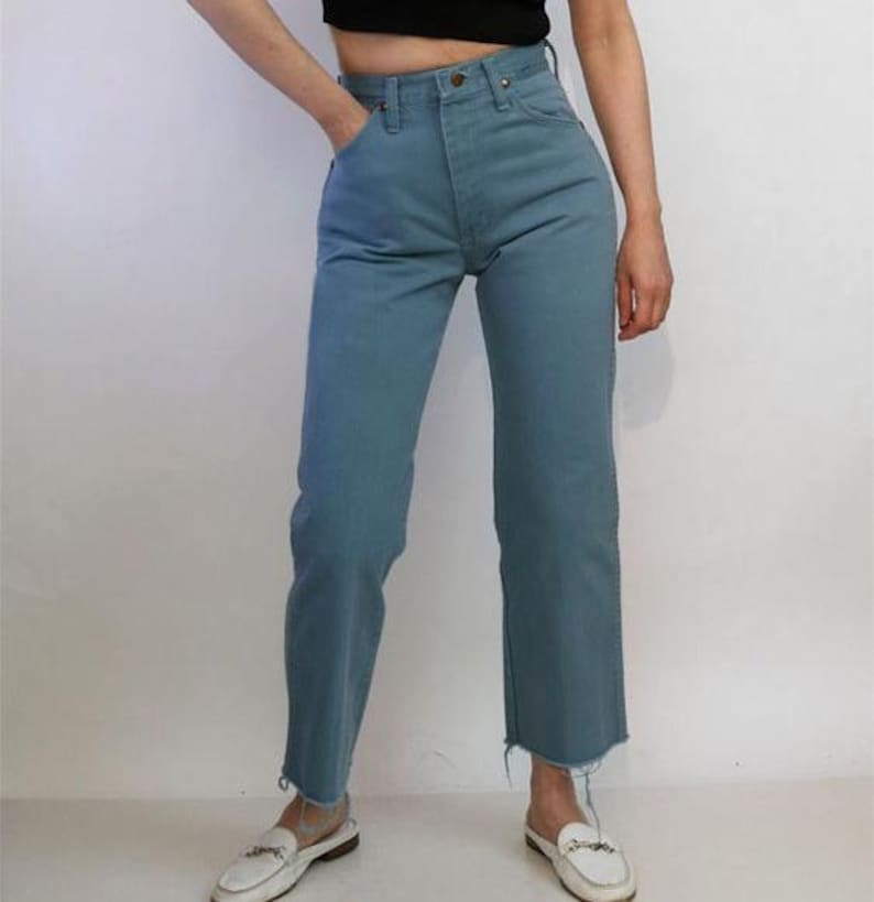 May include: A pair of light blue denim jeans with a high waist and a straight leg fit. The jeans have a frayed hem and are made of a soft, comfortable fabric.