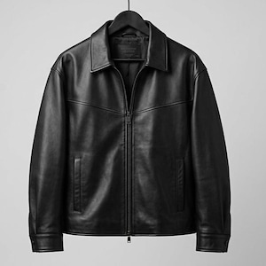 Puede incluir: Chaqueta de cuero negro con cuello y cremallera completa. La chaqueta tiene dos bolsillos delanteros y está colgada de una percha negra. Un estilo de ropa clásico.