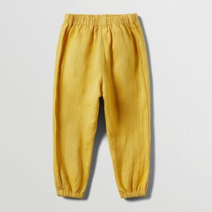 May include: Mustard yellow pants with an elastic waistband and gathered ankles. The pants are made of a lightweight fabric, perfect for warm weather. The casual style is suitable for everyday wear.
