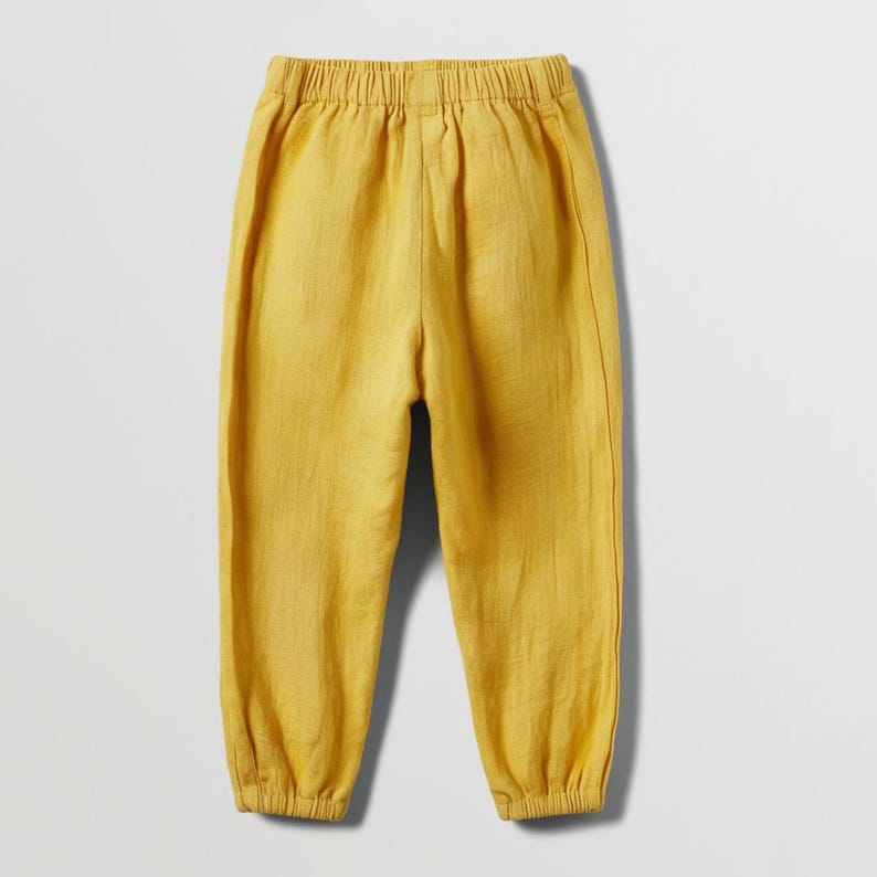 May include: Mustard yellow pants with an elastic waistband and gathered ankles. The pants are made of a lightweight fabric, perfect for warm weather. The casual style is suitable for everyday wear.