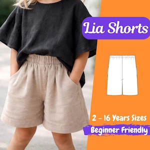 May include: A child wearing a black top and tan shorts with pockets. The shorts have an elastic waistband. The image includes the text "Lia Shorts", "2 - 16 Years Sizes", and "Beginner Friendly". A diagram of the shorts is also shown.