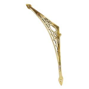 May include: A gold-colored, decorative shelf bracket with an openwork design. The bracket has a curved shape with geometric cutouts and a pointed end. The metal has a polished finish, and the bracket is against a white background.