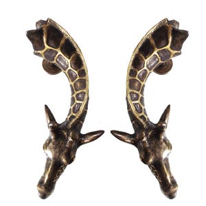 Peut inclure: Une paire de poignées de porte en laiton antique en forme de tête de girafe. Les poignées sont détaillées avec un motif de girafe et ont une finition brun foncé.