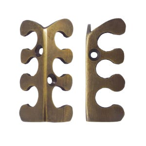 May include: Two antique brass-toned metal decorative corner brackets. Each bracket has a unique shape with multiple curved cutouts and small circular holes. The brackets are designed to be used on furniture or other decorative projects.