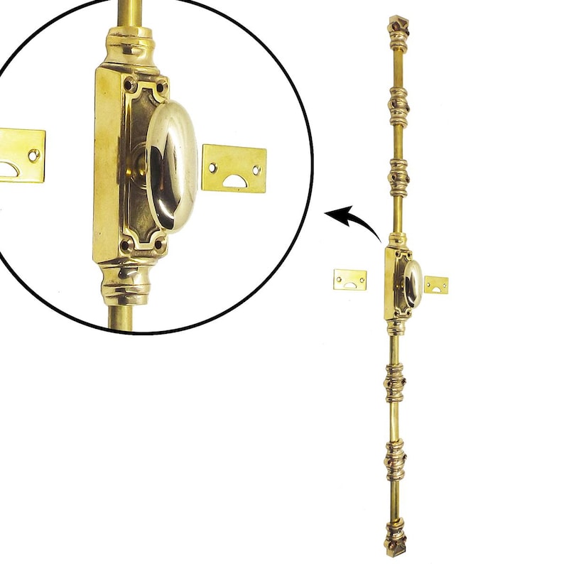 May include: A brass door bolt with an oval handle and decorative detailing. The bolt is long and slender, with a series of ornate accents along its length. Includes two small brass strike plates. The hardware is shown against a white background.