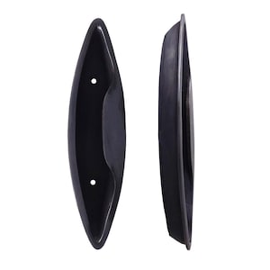 May include: Two black metal door handles with a rounded oval shape. The handles have a recessed area in the center for a grip.