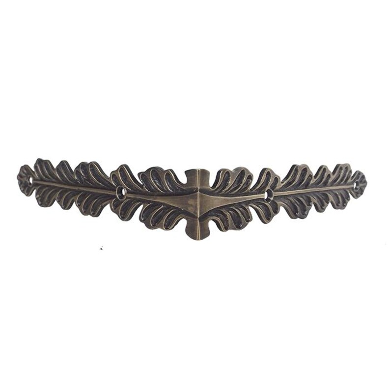 May include: A decorative metal corner bracket with a leaf design. The bracket is made of a dark, antique-looking metal and has a slightly curved shape.