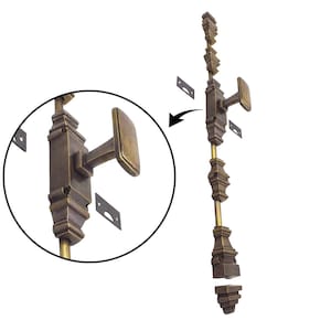 Może przedstawiać: Antyczny rygiel do drzwi z brązu z prostokątną rączką i dekoracyjnymi detalami. Rygiel jest pokazany z płytkami montażowymi i zbliżeniem. Okucia są przeznaczone do klasycznej lub zabytkowej estetyki.