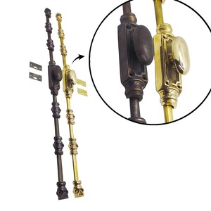 May include: Two antique window sash locks, one bronze and one brass, with matching mounting plates. The bronze lock has a dark finish, while the brass lock has a bright, polished appearance. Both locks feature oval knobs and decorative detailing.