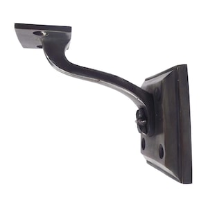 May include: A dark bronze-colored handrail bracket. The bracket has a square base with rounded edges and a curved arm that connects to a rectangular mounting plate. The design is simple and functional.