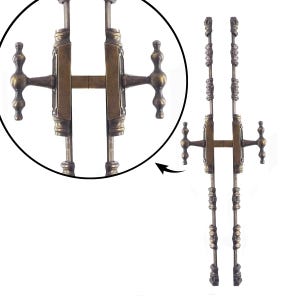 Op de afbeelding: Antieke bronzen deurklinken met een sierlijk ontwerp. De klinken hebben een centrale H-vormige structuur met decoratieve knoppen aan elk uiteinde. De lange, slanke staven hebben gedetailleerde versieringen, wat een vintage uitstraling geeft.