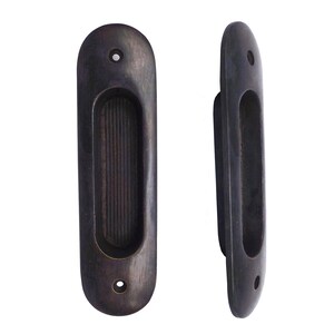 May include: Two black metal door pulls with a rectangular opening in the center. The pulls have a rounded oval shape and are designed to be flush mounted.