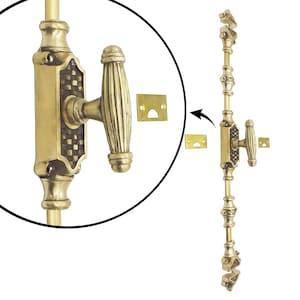 May include: A brass-toned window sash lock with an ornate design. The lock features a lever handle and decorative detailing, including a checkered pattern. Includes two small brass-colored strike plates.