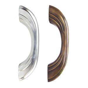 May include: Two door handles, one silver and one bronze, with a curved design and a series of raised lines.