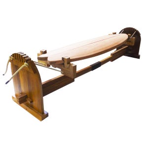 Puede incluir: Un soporte de tabla de surf de madera con una tabla de surf marrón claro. El soporte es de madera marrón claro y presenta un detalle de cuerda. La tabla de surf es de color marrón claro y tiene una forma larga y curvada. El soporte está diseñado para sujetar la tabla horizontalmente.