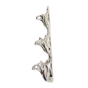 Puede incluir: Un soporte decorativo de metal plateado con un diseño floral. El soporte presenta tres formas estilizadas en forma de flor, cada una con un agujero para el montaje. El diseño es simétrico y tiene un acabado pulido.