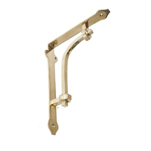 Può includere: Una singola staffa per mensola color oro con un design decorativo. La staffa ha un supporto curvo e una parte superiore piatta con fori preforati per il montaggio. Il metallo ha una finitura lucida, che riflette la luce.