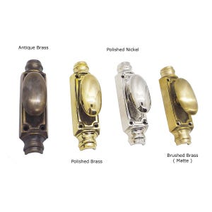 May include: Four different metal door knobs are displayed against a white background. The knobs are in antique brass, polished brass, polished nickel, and brushed brass (matte) finishes. Each knob has an oval handle and a rectangular base. The text labels each finish.