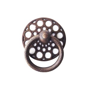 Op de afbeelding: Bronzen kastgreep met een cirkelvormige achterplaat met een patroon van kleine gaatjes. De greep heeft een getextureerde ringgreep en een centrale, afgeronde knop. De hardware is ontworpen voor meubels en voegt een vintage esthetiek toe.