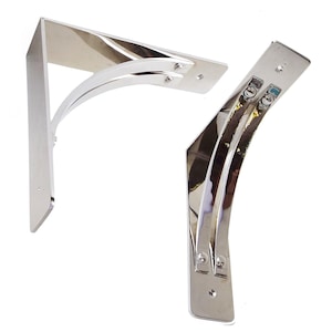 May include: Two silver metal shelf brackets with a curved design. The brackets are made of polished metal and have a shiny finish.