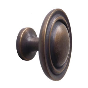 May include: Bronze-toned cabinet knob with a circular, layered design. The knob features a rounded face with concentric rings and a short, cylindrical stem for attachment. The hardware has a vintage aesthetic.
