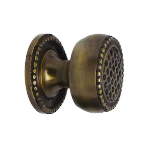 Pode incluir: Puxador de armário em latão antigo com uma face decorativa texturizada e uma borda com contas. O puxador tem um design clássico e vintage, perfeito para adicionar um toque de elegância a móveis ou armários. O puxador mede aproximadamente 3,8 cm de diâmetro.