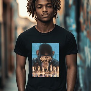 Può includere: Una maglietta nera con una grafica di una scimmia che indossa occhiali da sole e gioca a scacchi. La scimmia indossa una giacca di pelle e i pezzi degli scacchi sono dorati.