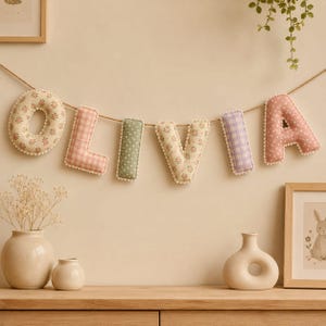 Personalized fabric name banner made using puffy fabric letter sewing patterns.