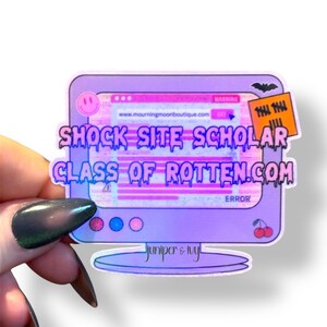 May include: A holographic sticker featuring a retro computer design with the text "SHOCK SITE SCHOLAR CLASS OF ROTTEN.COM". The sticker has a purple and pink color scheme, with a smiley face and cherries.