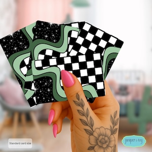 May include: A set of playing cards with a retro design. The cards feature a mix of black and white checkered patterns, wavy green lines, and a starry night sky. The text "Standard card size" is visible.